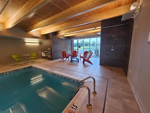 a swimming pool in a room with a table and chairs at Home2 Suites By Hilton Allentown Bethlehem Airport in Bethlehem
