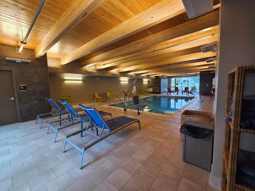 uma piscina com cadeiras azuis e uma piscina em Home2 Suites By Hilton Allentown Bethlehem Airport em Bethlehem