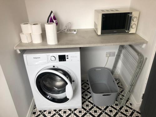 a laundry room with a washing machine and a microwave at No 7 - 3 Bed House, Parking, Walkable to City, Quiet Location in Sunderland