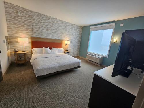 a bedroom with a bed and a flat screen tv at Home2 Suites By Hilton Allentown Bethlehem Airport in Bethlehem