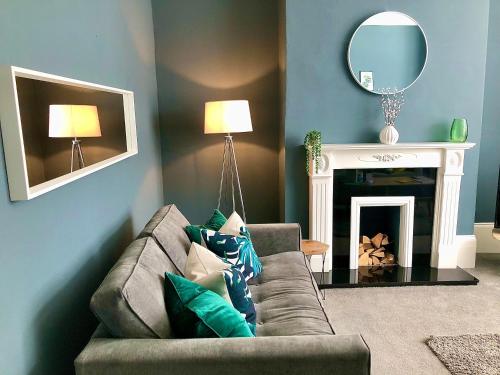 a living room with a couch and a mirror at No 7 - 3 Bed House, Parking, Walkable to City, Quiet Location in Sunderland