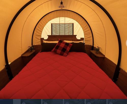 een groot rood bed in een kamer met een raam bij Wagon - 03 Lockridge Park in Danville