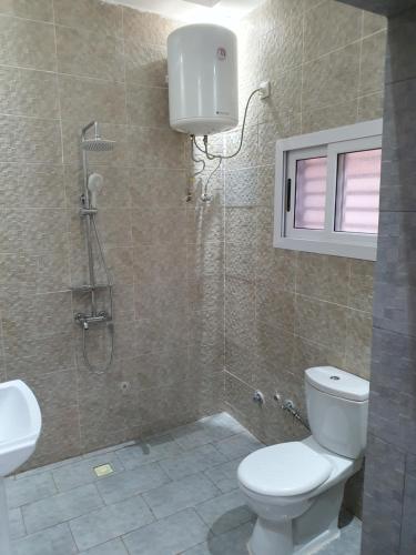 La salle de bains est pourvue de toilettes, d'une douche et d'un lavabo. dans l'établissement Villa meuble golf, à Bamako