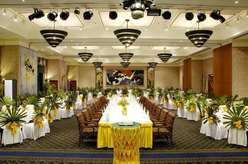 a banquet hall with tables and chairs and plants at The Royal Paradise Hotel & Spa - SHA Extra Plus in Patong Beach
