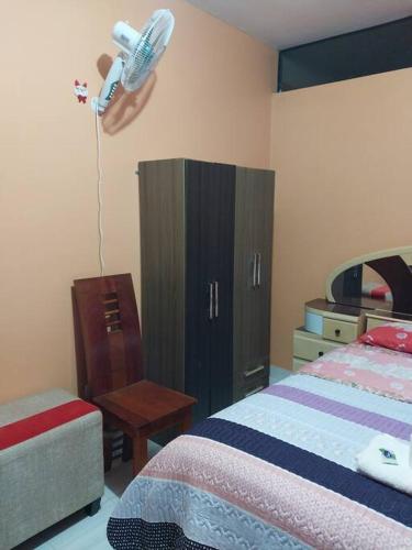 1 dormitorio con 1 cama y vestidor con ventilador en la pared en D203 en Moyobamba