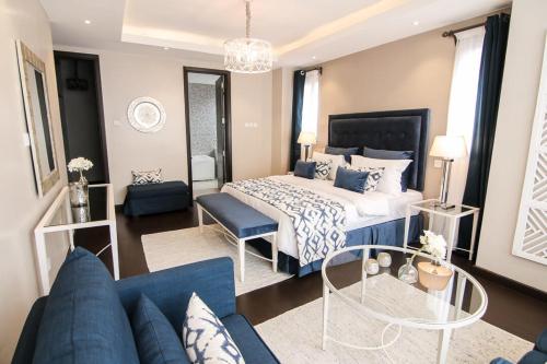 a bedroom with a large bed and a blue couch at Jancy Properties in Nairobi