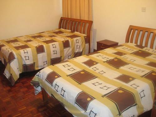 a room with three beds in a room at Jancy Properties in Nairobi