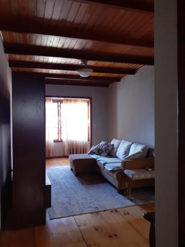 ein Wohnzimmer mit einem Sofa und einem Fenster in der Unterkunft Chalé ensolarado, bairro Frei Rogerio in Lages