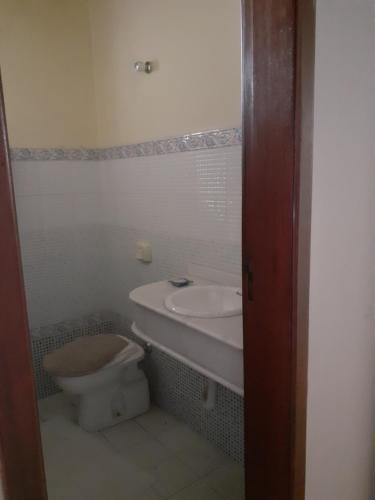 La salle de bains est pourvue d'un lavabo et de toilettes. dans l'établissement Chalé ensolarado, bairro Frei Rogerio, à Lages