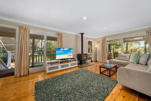 a living room with a couch and a flat screen tv at Maggies Nest in Blackheath
