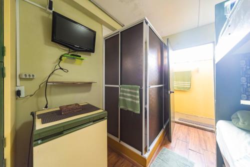 a small room with a refrigerator and a tv at Hostel Multiverso in Santo André