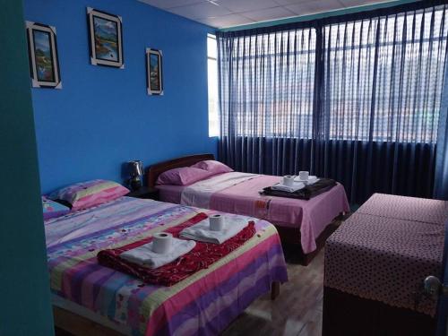 2 camas en una habitación con paredes azules en D301, en Moyobamba