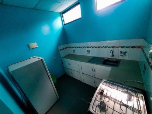 uma cozinha azul com um lavatório e uma janela em D301 em Moyobamba