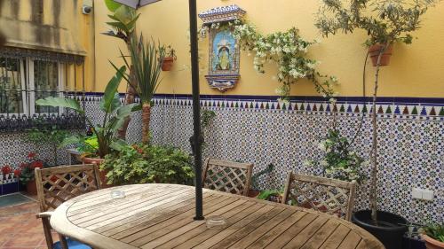 a wooden table with two chairs and a clock on the wall at Dormir en Cádiz in Cádiz