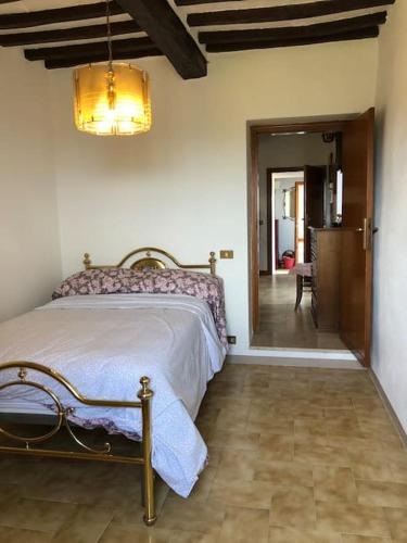 a bedroom with a bed and a hallway with a door at Al Renaio in Sarteano