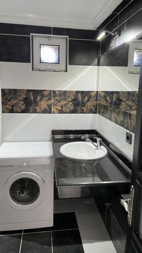a bathroom with a sink and a washing machine at Tourist pansiyon 2 in Antalya