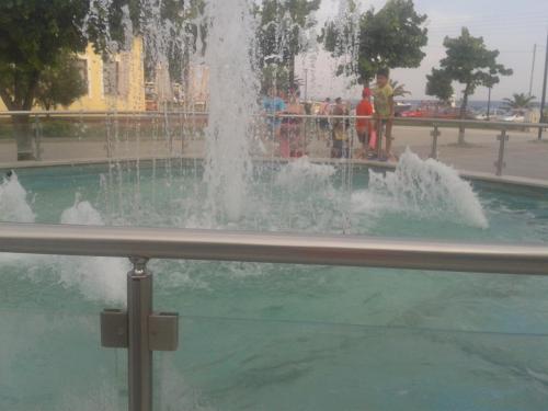 ネア・カリクラティアにあるMouses-Xの周囲に人が立つ公園の噴水