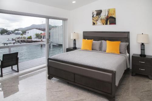a bedroom with a bed and a view of the water at 232B South Finger in Jolly Harbour