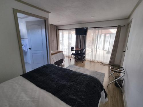 a bedroom with a bed and a room with a window at Casa Hotel Trocha Angosta in Constitución