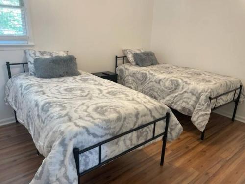 a bedroom with two beds and a wooden floor at Modern home steps to historic downtown Salisbury in Salisbury