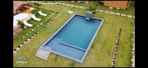 un rendimiento de una piscina en un patio en Pousada Corália, en São Miguel dos Milagres