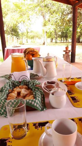 a table with a plate of food and cups on it at Posada Turística Vicenta Aguayo in Yaguarón