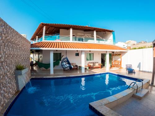 a villa with a swimming pool in front of a house at CASA TORRES in Bonito