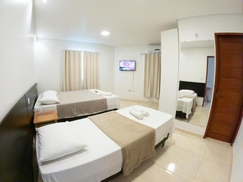 a hotel room with two beds and a mirror at CASA TORRES in Bonito