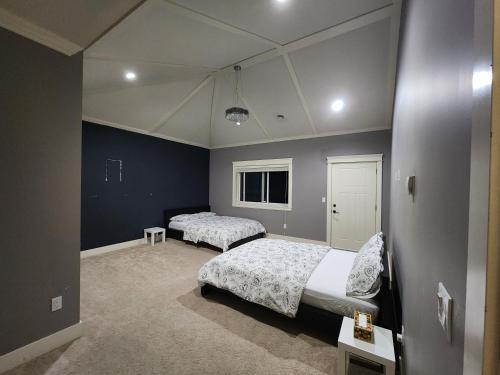 1 dormitorio con 2 camas y paredes azules en Harmony Hospitality "Walking Distance to Surrey Central", en Surrey