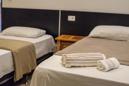 a hotel room with two beds with towels on them at CASA TORRES in Bonito