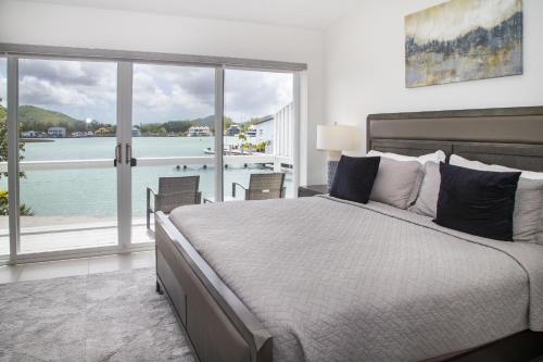 a bedroom with a large bed with a view of the water at 232C South Finger in Jolly Harbour