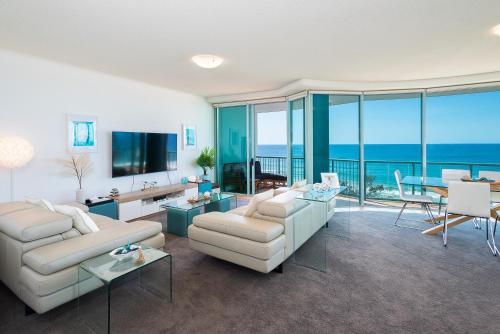 a living room with white furniture and a view of the ocean at The Waterford on Main Beach in Gold Coast