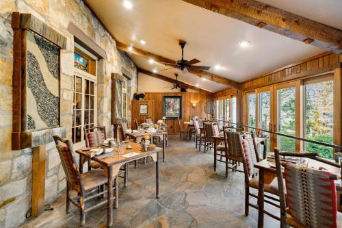 ロビンズビルにあるSnowbird Mountain Lodge - All-Inclusive Adventureのテーブルと椅子と窓のあるレストラン