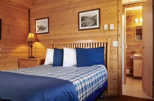a bedroom with a blue bed in a cabin at Klondike Kate's Cabins in Dawson City