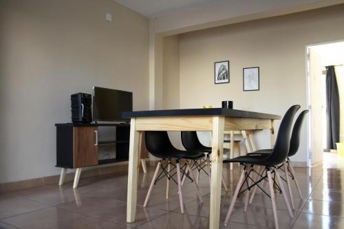 una mesa de madera con sillas negras en una habitación en Chañares Centric Apartment en Mendoza