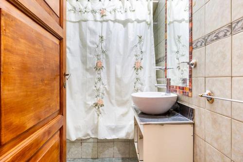 baño con lavabo y cortina de ducha blanca en Eco Hogar Mza en Mendoza