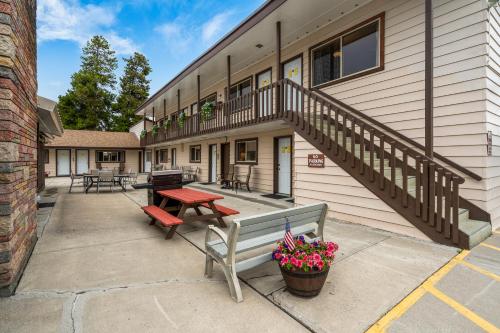 ein Gebäude mit einer Bank, einem Tisch und einer Treppe in der Unterkunft Lazy Duck Inn in West Yellowstone