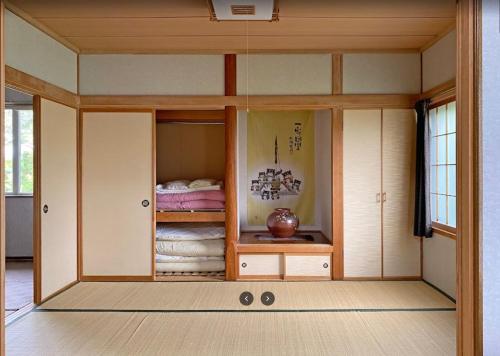 a small room with a bed in a room at FURANO UEDA HOUSE in Furano