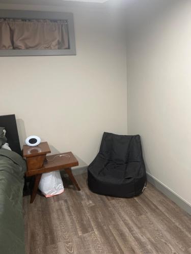ein Schlafzimmer mit einem Bett, einem Stuhl und einem Tisch in der Unterkunft Spacious Room & Living Area in NW! in Calgary