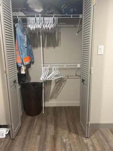 einen begehbaren Kleiderschrank mit einer Tür zu einem Zimmer in der Unterkunft Spacious Room & Living Area in NW! in Calgary
