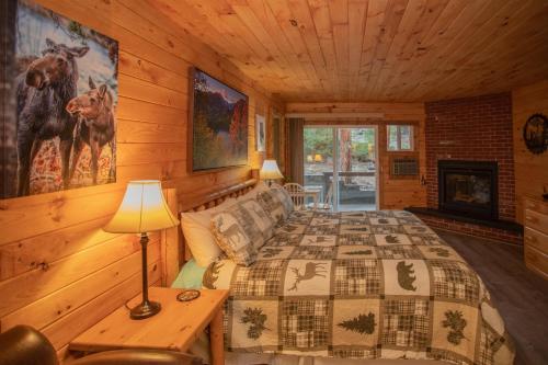 a bedroom with a bed and a fireplace in a cabin at Nicky's Resort in Estes Park