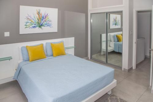 a bedroom with a bed with yellow and blue pillows at 246D South Finger in Jolly Harbour