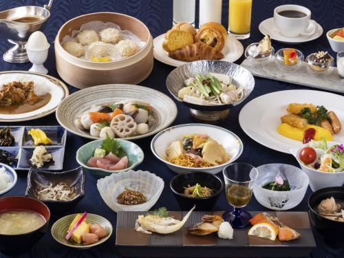 a table with many plates of food on it at Ark Hotel Royal Fukuoka Tenjin -ROUTE INN HOTELS- in Fukuoka