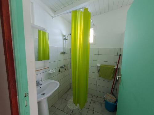 baño con cortina de ducha amarilla y lavamanos en O 4 épices gites, en Capesterre-Belle-Eau
