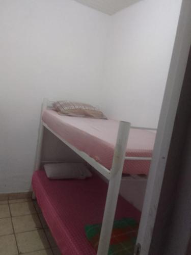 Ce lit superposé se trouve dans une petite chambre avec un matelas. dans l'établissement Pousada Garcia, à São Paulo