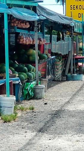 a produce stand with a bunch of watermelons on display at Rizki Homestay Nibong Tebal in Nibung Tebal