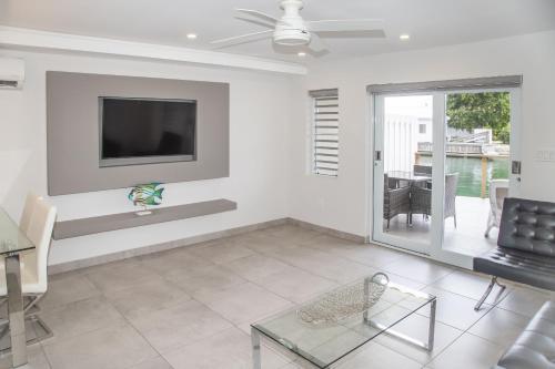 a living room with a television and a table and chairs at 246D South Finger in Jolly Harbour