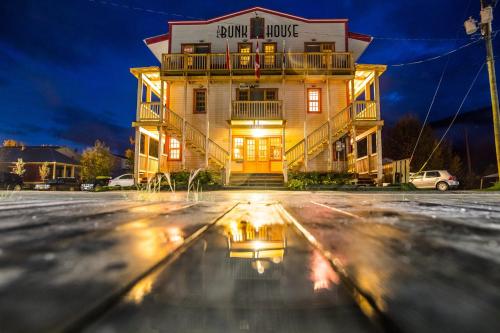 ein Gebäude mit einem Spiegelbild in einer Pfütze auf der Straße in der Unterkunft The Bunkhouse in Dawson City