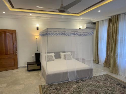 a bedroom with a bed with a canopy at West Coast Villa in Limbe