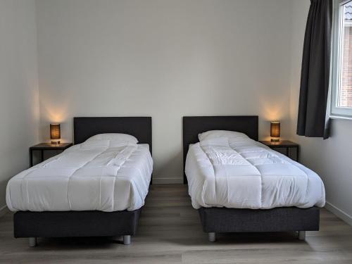 twee bedden naast elkaar in een kamer bij Nice holiday home in Simonshaven with garden in Simonshaven